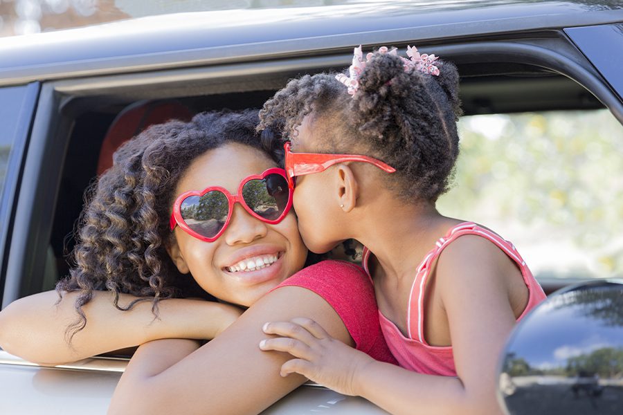 Personal Insurance - Happy Sisters with Heart Shaped Sunglasses in Car Ready for Summer